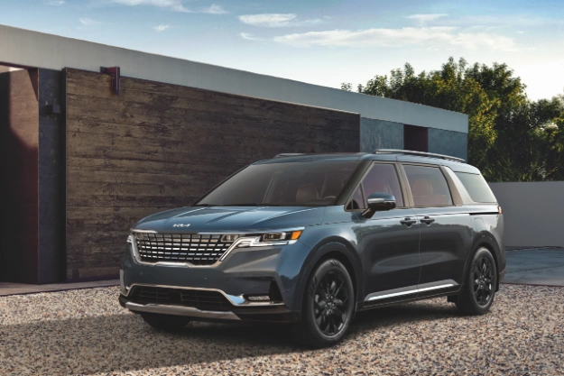 2024 Kia Carnival Parked On A Gravel Driveway Three-Quarter View 