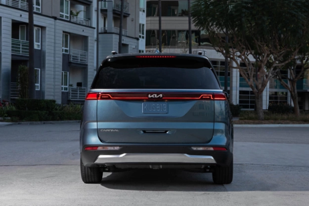 2024 Kia Carnival Parked In Front Of An Apartment Complex Rear-View 