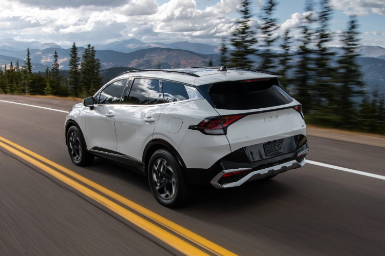 2024 Kia Sportage Driving On An Elevated Highway Rear Three-Quarter View