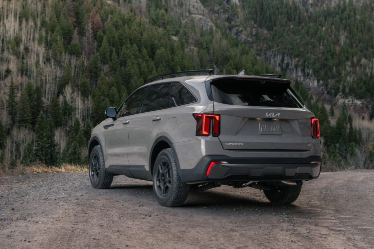 2024 Kia Sorento in brown, three-quarter back view, parked by a mountain