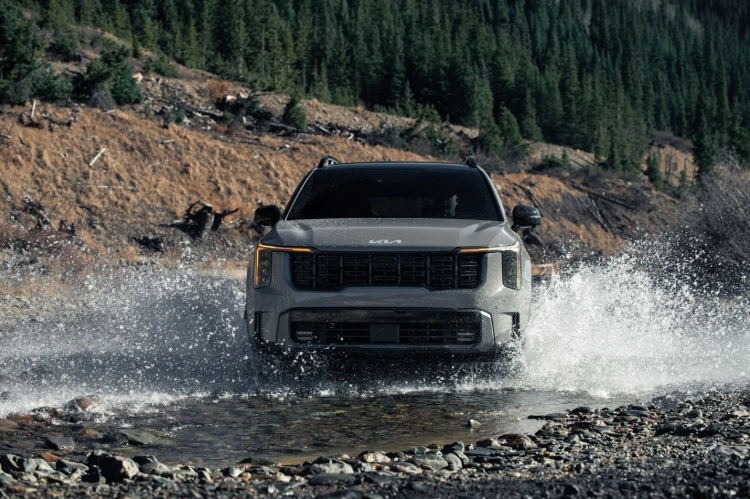 2024 Kia Sorento, front view, driving through water in the mountains making a huge splash