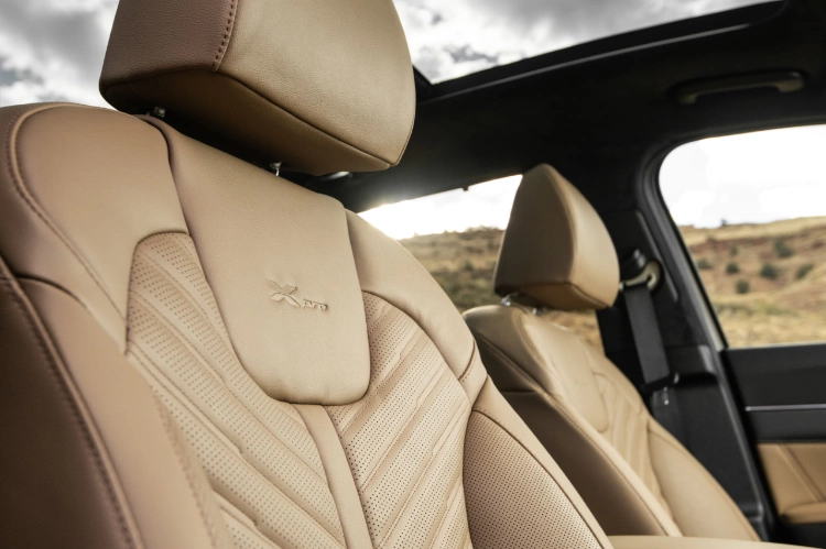 2024 Kia Sorento interior, zoomed in view of the brown leather passenger seat featuring chevron detailing and the "X-Pro" emblem