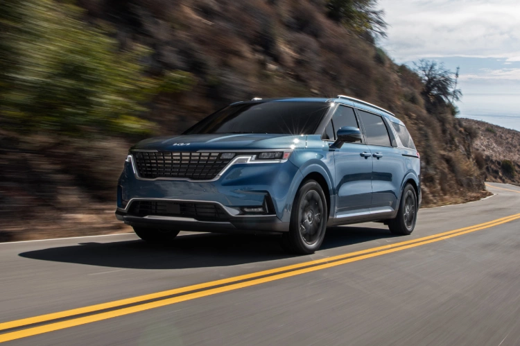 2024 Kia Carnival Driving Up A Mountain Highway Three-Quarter View