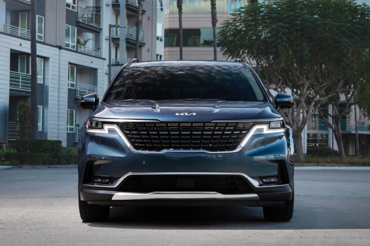 2024 Kia Carnival Parked In Front Of An Apartment Complex Front-View 